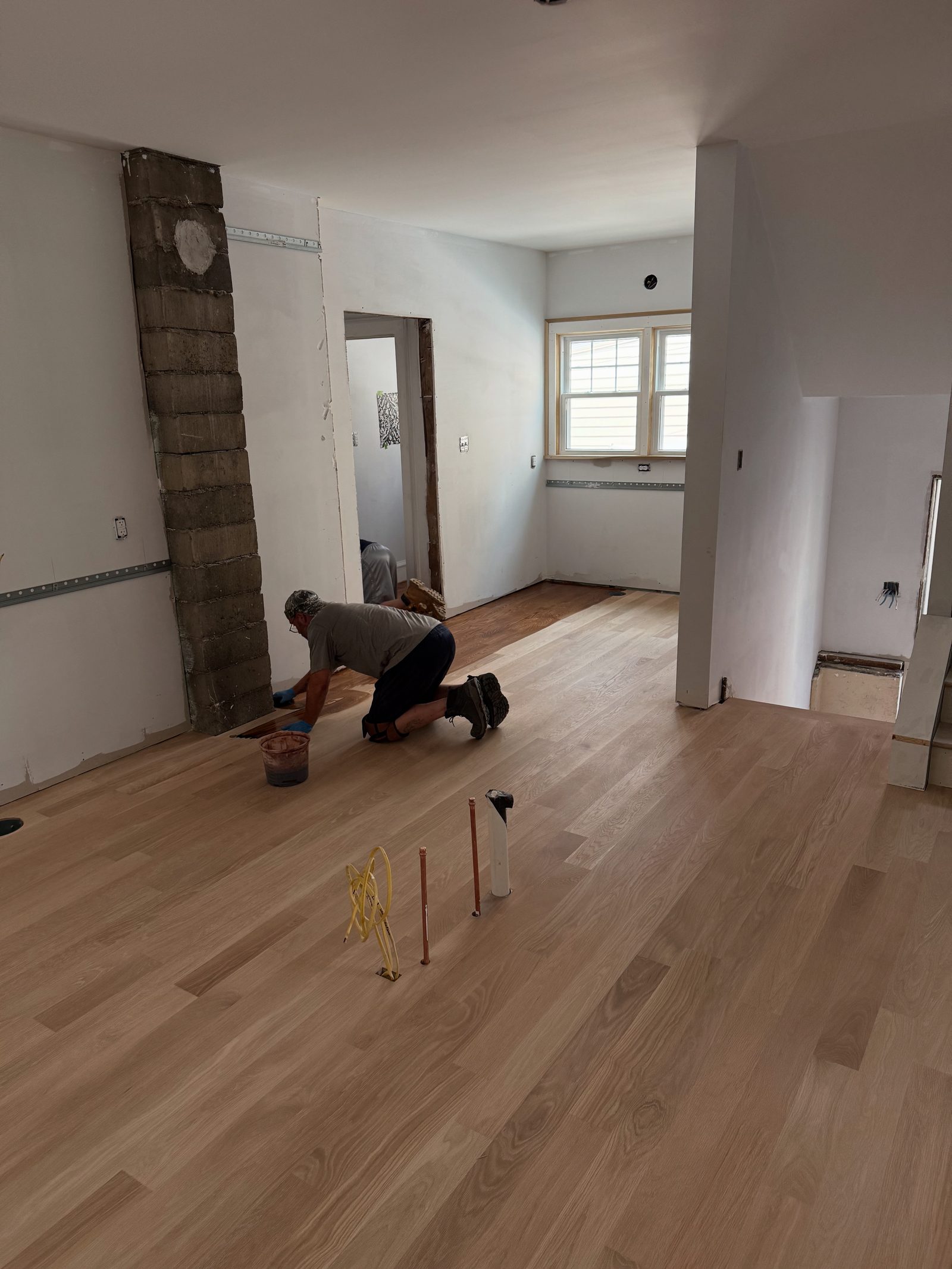 Installer applying finish to hardwood floor during a Cleveland-area renovation